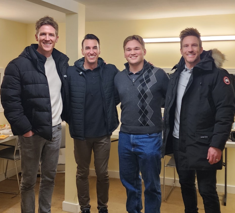 Corwin Belnap standing with the group GENTRI in a dressing room